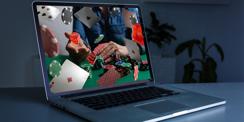 Cards and poker chips appear to flying out of a laptop screen