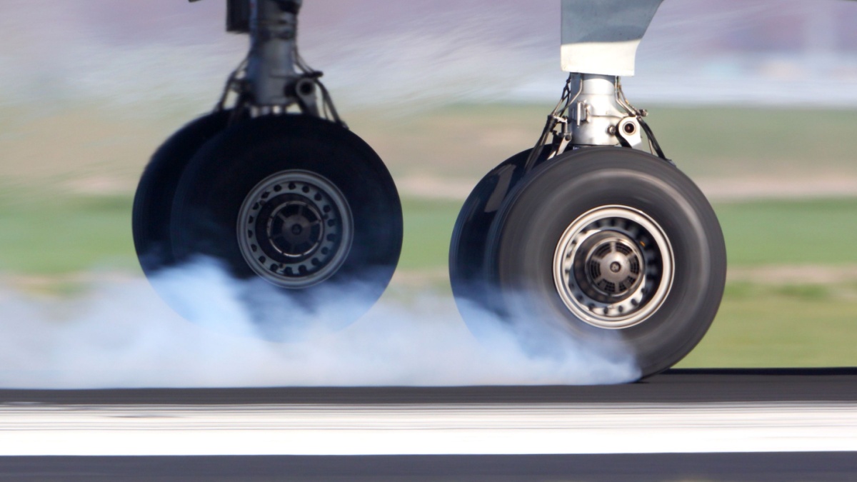 Close up of a planes landing gear as it touches down