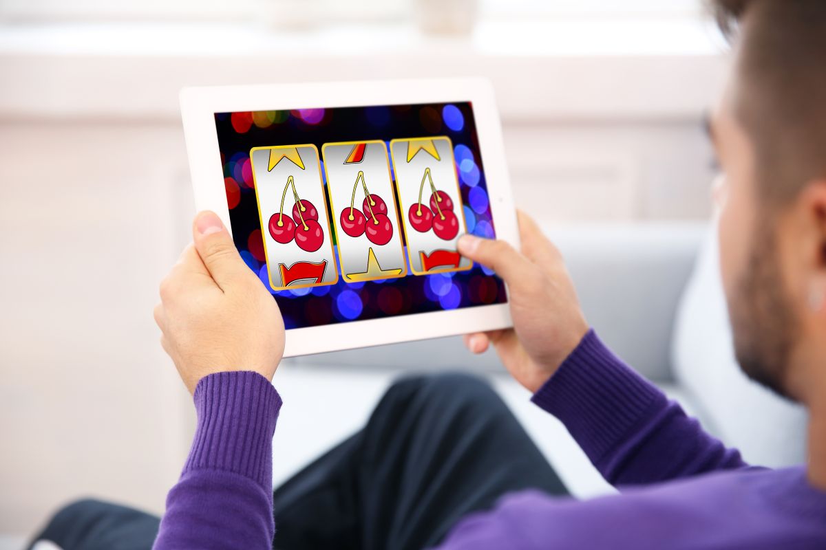 A man playing an online slots game on a tablet device