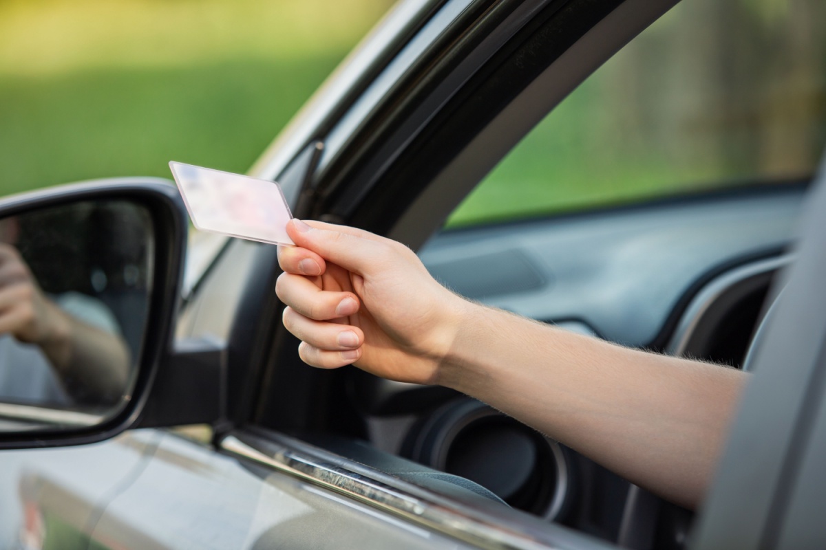 Incentive Games awarded a new license as a driver hands over his license.