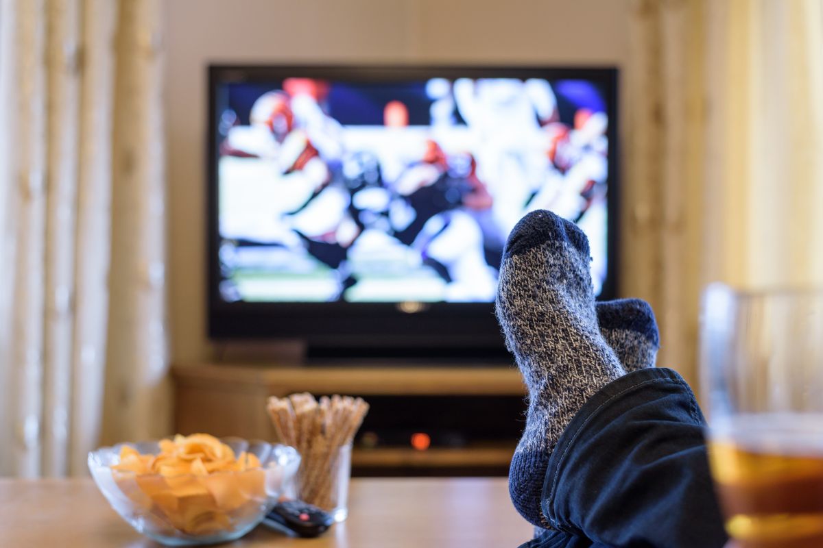 A person with their feet up watching American football