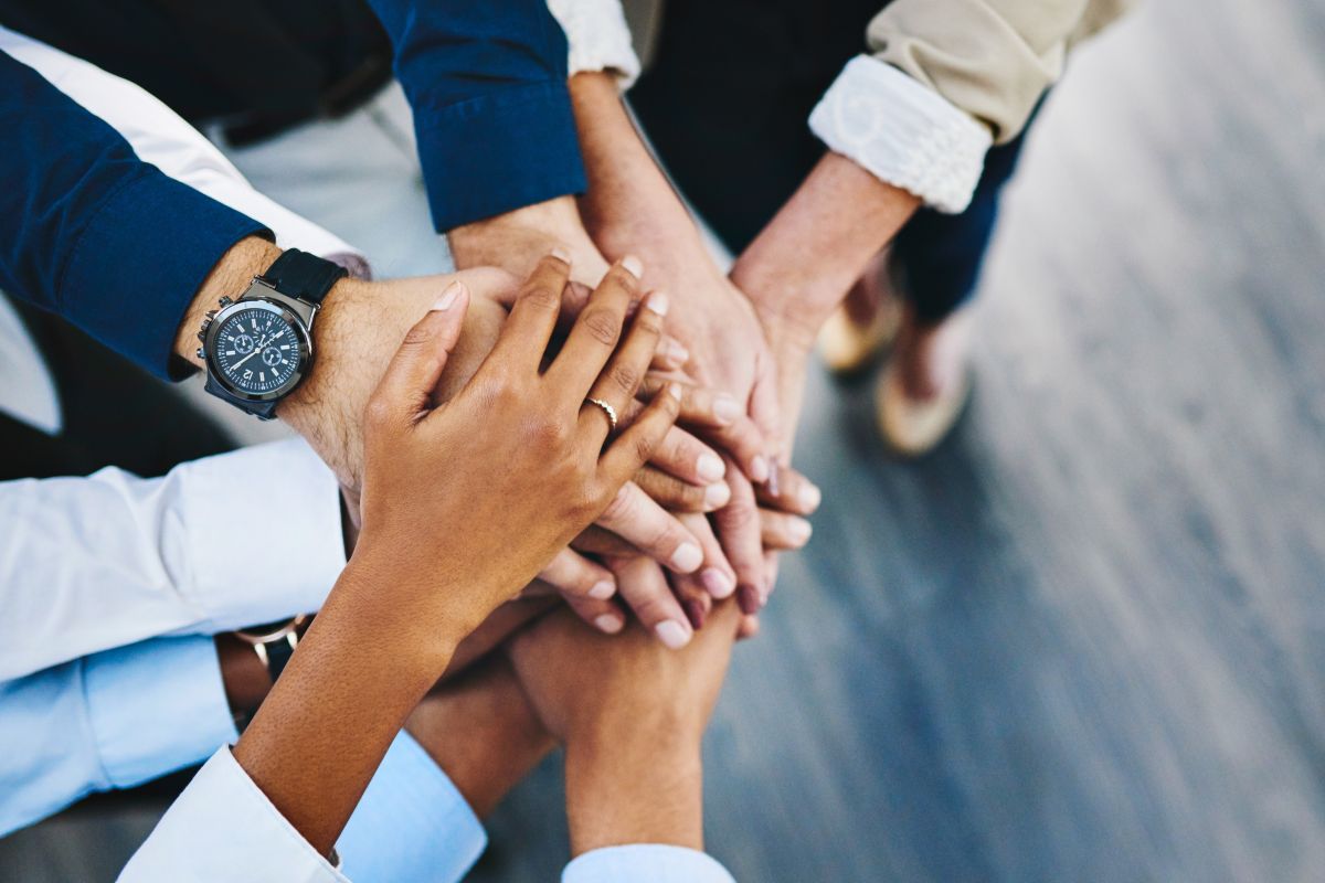 People putting their hands on top of one another's in a show of unity