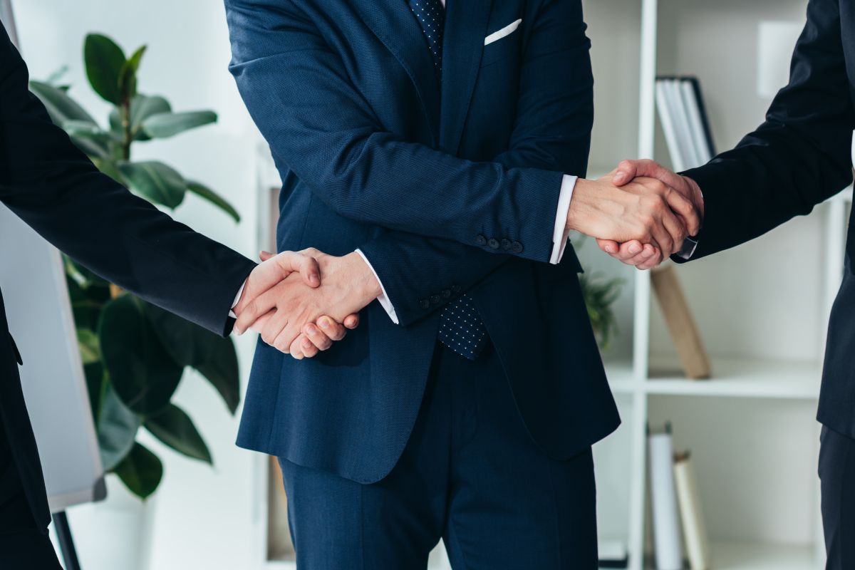A person shaking hands on two business deals at the same time