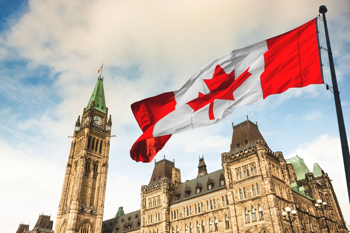The flag of Canada flying in front of the Parliament building in Ottawa