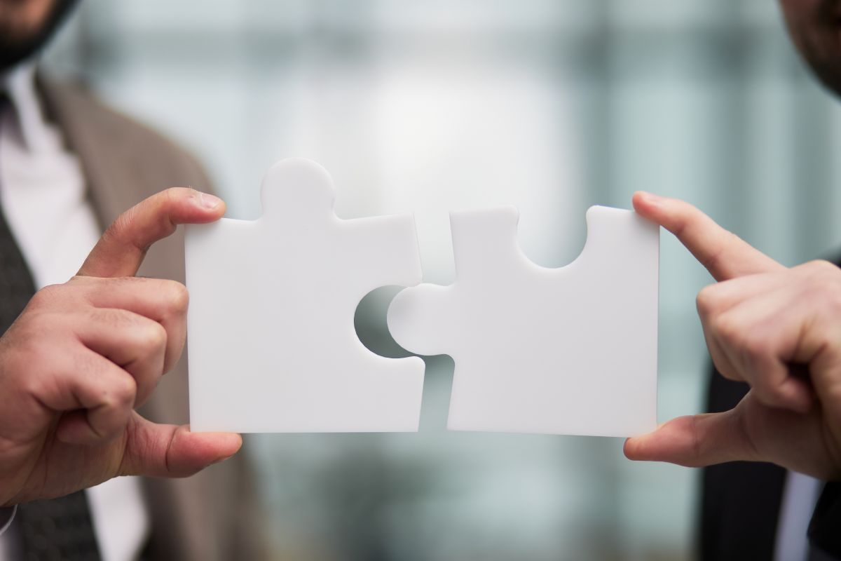 Two people putting puzzle pieces together