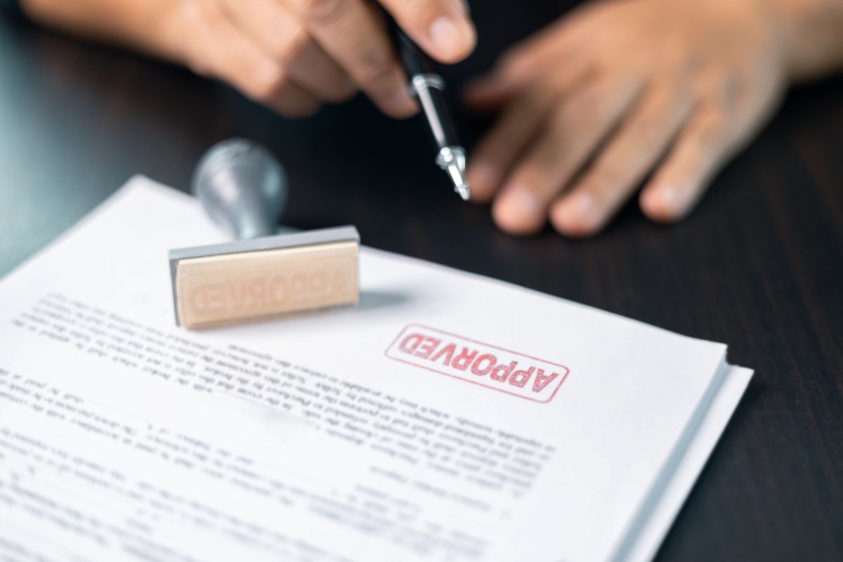 Somebody giving a paper document a stamp of approval