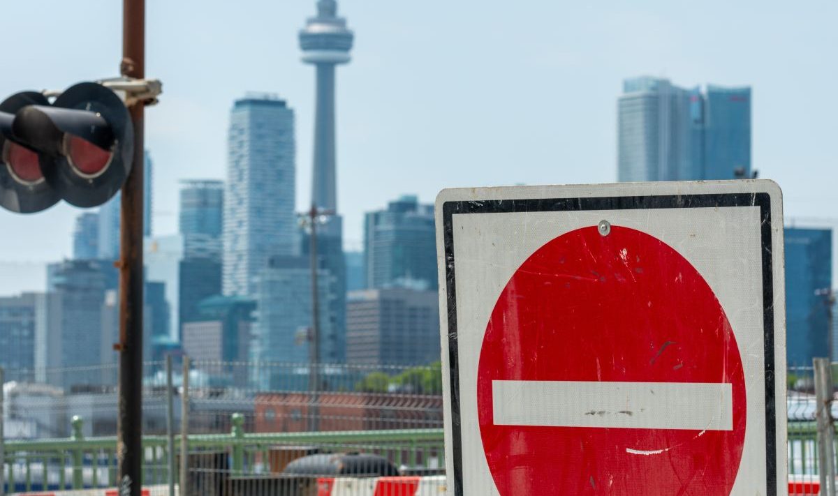 A no entry sign with Toronto's CN Tower in the background
