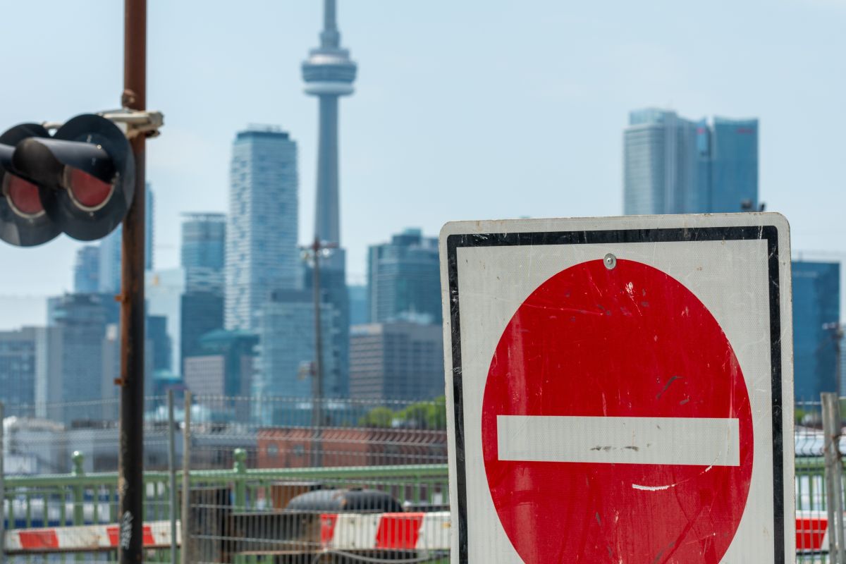 A no entry sign with Toronto's CN Tower in the background