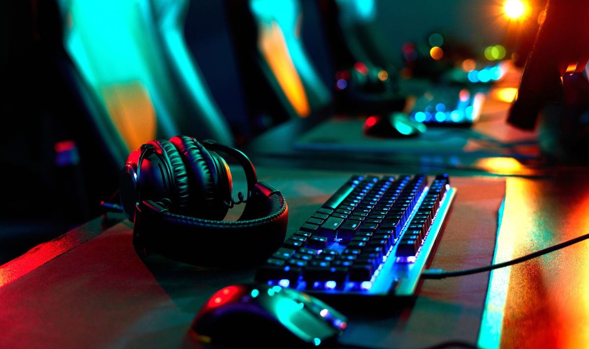 A gaming computer, mouse, keyboard, and headset with nobody using them