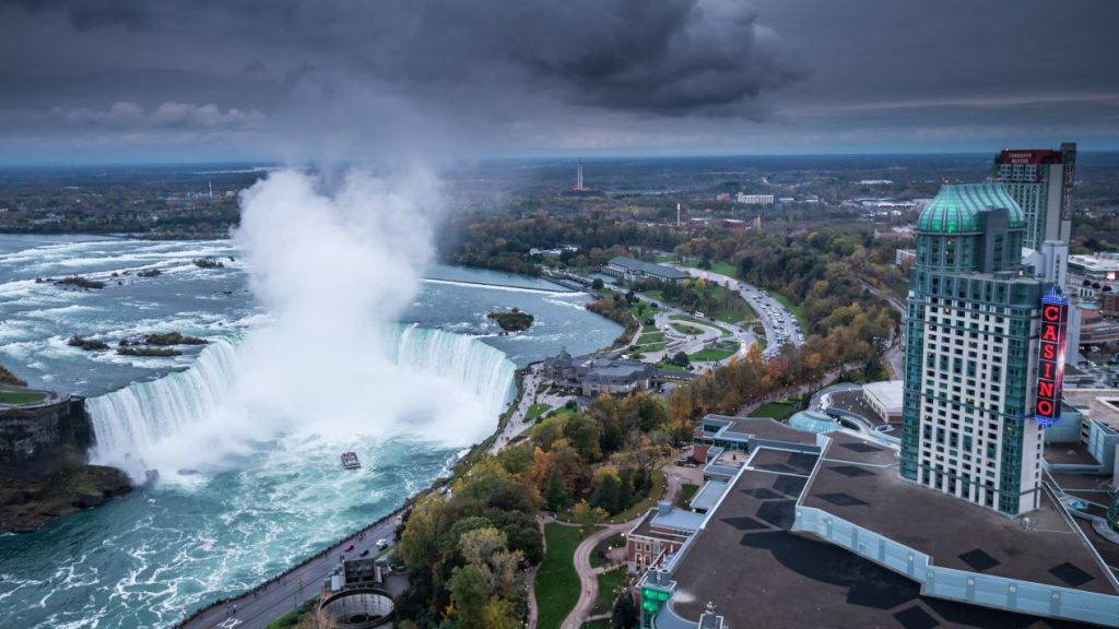 A view of Niagara Falls on a dark grey day with Casino Niagara visible on the right