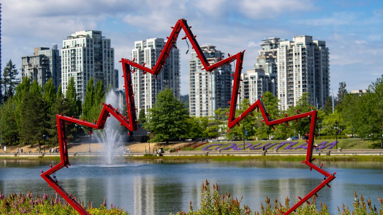 A view of Coquitlam town center park with a maple leaf installation in the foreground