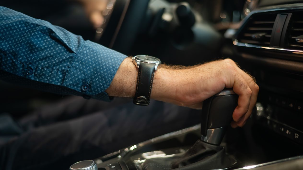 A man shifting gears in his car