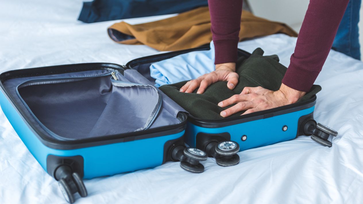 A person packing clothes into a suitcase