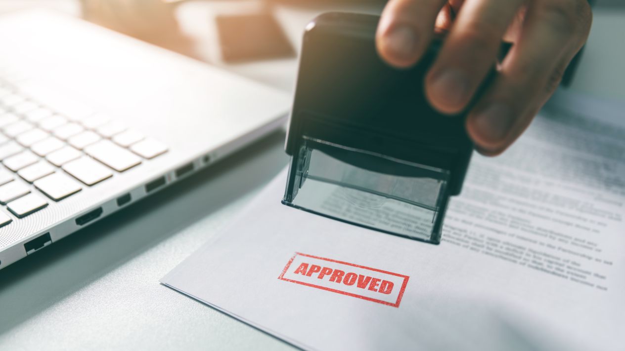 A person stamping approval on a document