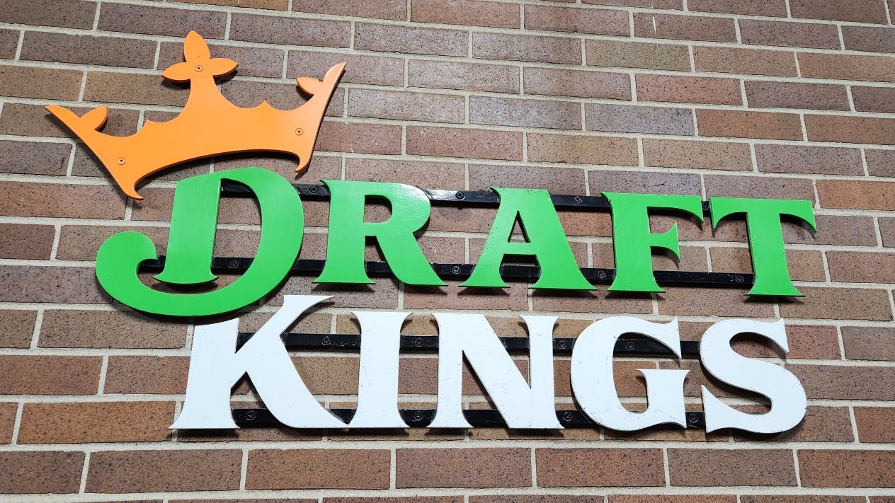 The DraftKings logo on a brick wall